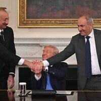 US President Donald Trump (C), Azerbaijani President Ilham Aliyev (L) and Armenian Prime Minister Nikol Pashinyan shake hands after signing an agreement in the State Dining Room of the White House in Washington, DC, on August 8, 2025 (ANDREW CABALLERO-REYNOLDS / AFP)