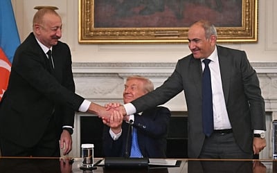 US President Donald Trump (C), Azerbaijani President Ilham Aliyev (L) and Armenian Prime Minister Nikol Pashinyan shake hands after signing an agreement in the State Dining Room of the White House in Washington, DC, on August 8, 2025 (ANDREW CABALLERO-REYNOLDS / AFP)