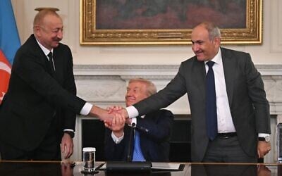 US President Donald Trump (C), Azerbaijani President Ilham Aliyev (L) and Armenian Prime Minister Nikol Pashinyan shake hands after signing an agreement in the State Dining Room of the White House in Washington, DC, on August 8, 2025 (ANDREW CABALLERO-REYNOLDS / AFP)