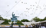 Doves fly past the 'Peace Statue' in Nagasaki, Japan, after being released into the air during the 80th annual memorial for the US nuclear bombing of the city in World War II, August 9, 2025. (JIJI PRESS / AFP)
