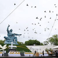 Doves fly past the 'Peace Statue' in Nagasaki, Japan, after being released into the air during the 80th annual memorial for the US nuclear bombing of the city in World War II, August 9, 2025. (JIJI PRESS / AFP)