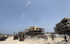 Palestinians run as a military aircraft drops parcels humanitarian aid in Jabalia in the northern Gaza Strip, on August 9, 2025. (Bashar TALEB / AFP)