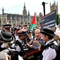 Police officers remonstrate with a protester during a 'Lift The Ban' demonstration in support of the proscribed group Palestine Action, at Parliament Square, central London, on August 9, 2025. (HENRY NICHOLLS / AFP)