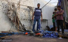 Palestinian children and a journalist examine the destroyed Al Jazeera tent at Al-Shifa Hospital in Gaza City on August 11, 2025, following an overnight strike by the IDF. (BASHAR TALEB / AFP)