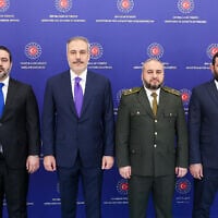 Turkish Foreign Minister Hakan Fidan (2nd L) posing for a photograph next to Syrian Foreign Minister Asaad al-Shaibani (L), Syrian Defence Minister Murhaf Abu Qasra (2nd R) and Head of Syrian Intelligence Hussein al-Salama during a meeting in Ankara, Turkey, on August 13, 2025.  (HANDOUT / TURKISH FOREIGN MINISTRY / AFP)