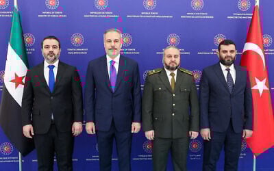 Turkish Foreign Minister Hakan Fidan (2nd L) posing for a photograph next to Syrian Foreign Minister Asaad al-Shaibani (L), Syrian Defence Minister Murhaf Abu Qasra (2nd R) and Head of Syrian Intelligence Hussein al-Salama during a meeting in Ankara, Turkey, on August 13, 2025.  (HANDOUT / TURKISH FOREIGN MINISTRY / AFP)