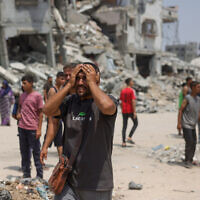 A man reacts as medics transport casualties of reported Israeli strikes in the Saftawi neighborhood west of Jabalia in the northern Gaza Strip on August 13, 2025. (Photo by Bashar TALEB / AFP)