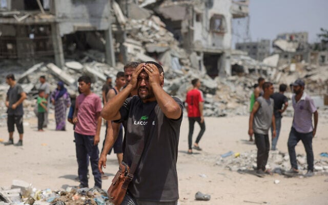 A man reacts as medics transport casualties of reported Israeli strikes in the Saftawi neighborhood west of Jabalia in the northern Gaza Strip on August 13, 2025. (Photo by Bashar TALEB / AFP)