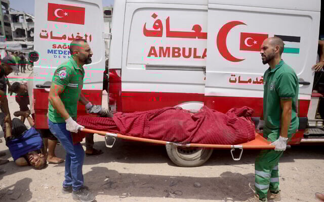 Medics carry casualties of reported Israeli strikes in the Saftawi neighborhood west of Jabalia in the northern Gaza Strip on August 13, 2025.  (Photo by Bashar TALEB / AFP)