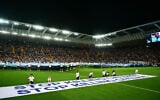 Mascots hold a banner which reads 'Stop killing children, Stop killing civilians' on the pitch ahead of the 2025 UEFA Super Cup final soccer match at the Friuli stadium, in Udine, Italy, August 13, 2025. (Marco BERTORELLO / AFP)