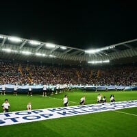Mascots hold a banner which reads 'Stop killing children, Stop killing civilians' on the pitch ahead of the 2025 UEFA Super Cup final soccer match at the Friuli stadium, in Udine, Italy, August 13, 2025. (Marco BERTORELLO / AFP)