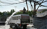 A man fills a tanker delivery truck with water from an underground water well distribution facility in Beirut on July 3, 2025. (Joseph EID / AFP)