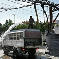 A man fills a tanker delivery truck with water from an underground water well distribution facility in Beirut on July 3, 2025. (Joseph EID / AFP)