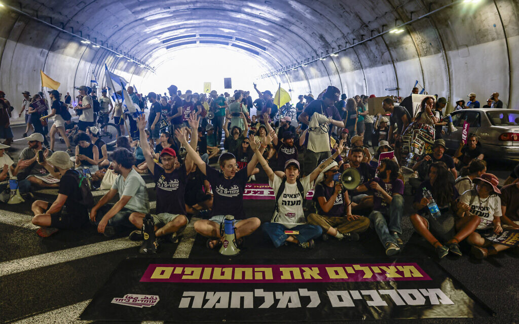 Families and supporters of Israelis held hostage by Hamas terrorists in Gaza since the October 7, 2023, attacks chant slogans as they block traffic in a tunnel during a protest calling for government action to secure their release in Jerusalem on August 17, 2025. (Menahem Kahana / AFP)