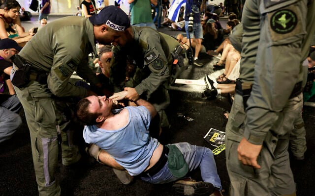 Israeli police remove demonstrators blocking traffic in a tunnel, as families and supporters of Israelis held hostage by Hamas terrorists in Gaza since the October 7, 2023 attack stage a protest calling for government action to secure their release in Jerusalem on August 17, 2025. (Menahem Kahana / AFP)