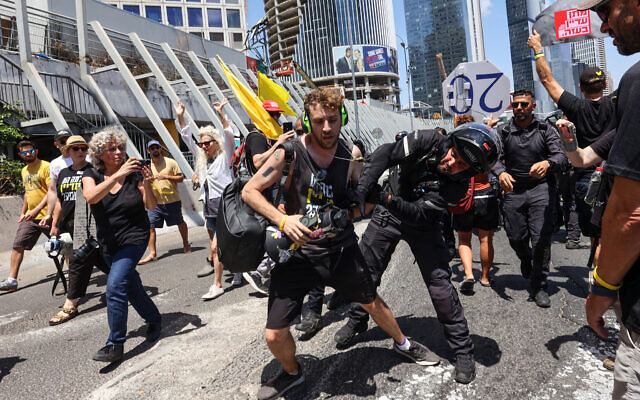 A member of the Israeli security forces arrests a demonstrator, during an anti-government protest demanding a deal to release Israelis held hostage in the Gaza Strip by Hamas since October 7, 2023, in Tel Aviv on August 17, 2025.  (Photo by GIL COHEN-MAGEN / AFP)