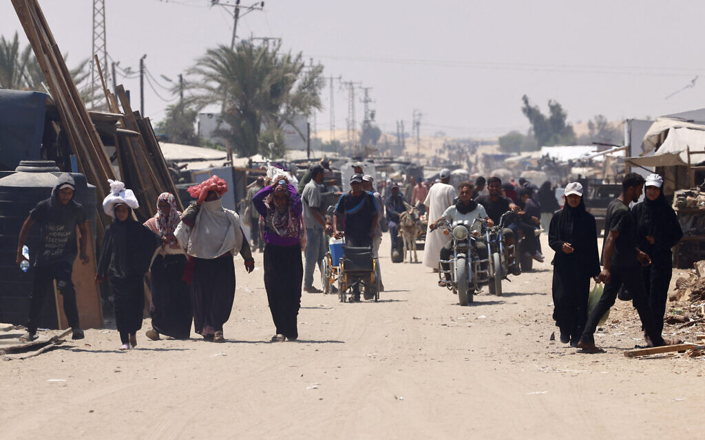 Palestinians carry humanitarian aid they gathered after an airdrop, as they walk in the al-Mawasi area, in the southern Gaza Strip on August 18, 2025. (AFP) Palestinians carry humanitarian aid they gathered after an airdrop, as they walk in the al-Mawasi area, in the southern Gaza Strip on August 18, 2025. (AFP)