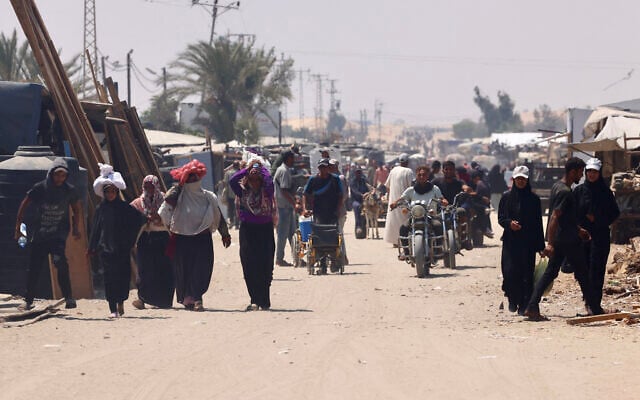 Palestinians carry humanitarian aid they gathered after an airdrop, as they walk in the al-Mawasi area, in the southern Gaza Strip on August 18, 2025. (AFP)