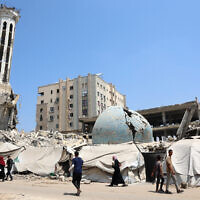 Palestinians walk past the destroyed Abu Khudra mosque in Gaza City on August 18, 2025. (Omar AL-QATTAA / AFP)