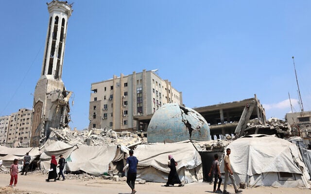 Palestinians walk past the destroyed Abu Khudra mosque in Gaza City on August 18, 2025. (Omar AL-QATTAA / AFP)
