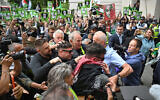 Irish rap group Kneecap band member, Naoise O Caireallain (center L), smiles as he arrives with band mate Liam O'Hanna at Westminster Magistrates' Courts in London on August 20, 2025, where O'Hanna  is set to be charged with a terror offense for supporting Hezbollah. (JUSTIN TALLIS / AFP)