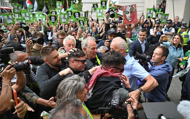 Irish rap group Kneecap band member, Naoise O Caireallain (center L), smiles as he arrives with band mate Liam O'Hanna at Westminster Magistrates' Courts in London on August 20, 2025, where O'Hanna  is set to be charged with a terror offense for supporting Hezbollah. (JUSTIN TALLIS / AFP)