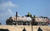 A truck transporting humanitarian aid drives down a road in Deir al-Balah in the central Gaza Strip on August 21, 2025. (Eyad Baba/AFP)