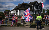 A protestor holds a Union Flag reading "Stop The Boats" during an anti-immigration protest outside the Sheraton Four Points hotel, believed to be housing asylum seekers, in Horley, south of London, on August 23, 2025. (Ben Stansall/AFP)