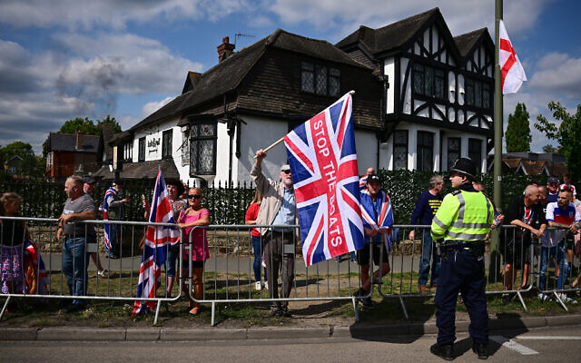 A protestor holds a Union Flag reading "Stop The Boats" during an anti-immigration protest outside the Sheraton Four Points hotel, believed to be housing asylum seekers, in Horley, south of London, on August 23, 2025. (Ben Stansall/AFP) A protestor holds a Union Flag reading "Stop The Boats" during an anti-immigration protest outside the Sheraton Four Points hotel, believed to be housing asylum seekers, in Horley, south of London, on August 23, 2025. (Ben Stansall/AFP)