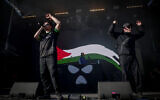 Pro-Palestinian, anti-Israel Northern Ireland hip-hop trio Kneecap perform on stage at the Rock en Seine music festival, in Saint-Cloud, near Paris, France, on August 24, 2025. (Guillaume BAPTISTE / AFP)