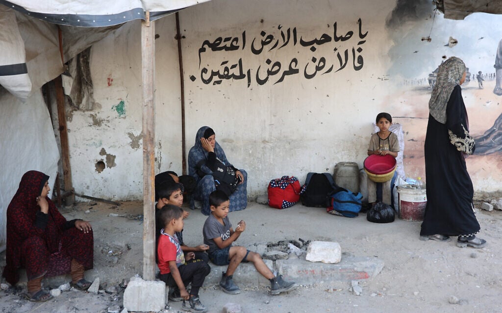 Palestinians rest on the side of a road as they flee their homes in Gaza City's Zeitoun neighbourhood on August 26, 2025. (Omar Al-Qattaa/AFP)
