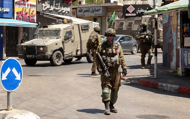 Israeli soldiers conduct a raid in the West Bank city of Ramallah, on August 26, 2025. (Zain JAAFAR / AFP)
