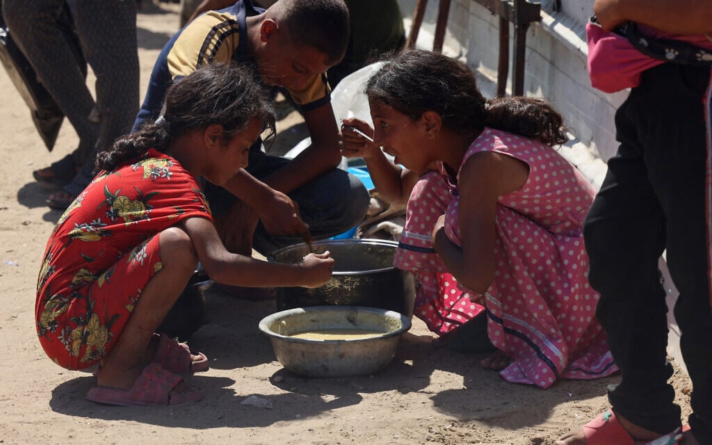 Palestinian children eat cooked rice from a charity kitchen in Khan Younis in the southern Gaza Strip on August 27, 2025. (AFP)