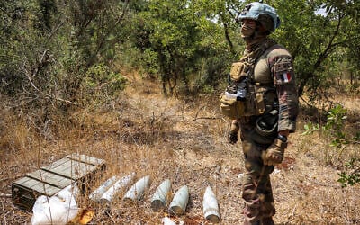 A French peacekeeper of the United Nations Interim Force in Lebanon (UNIFIL) stands by munitions formerly used by Iran-backed Hezbollah at a position that was held by the group in the Khraibeh Valley in el-Meri in south Lebanon on August 27, 2025. (ANWAR AMRO / AFP)