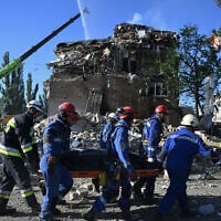 Ukrainian rescuers carry the body of a victim recovered during a search and rescue operation at the site of a residential building, heavily damaged following a Russian missile strike in Kyiv on August 28, 2025. (Genya SAVILOV / AFP)