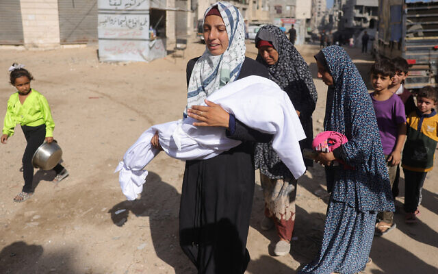 A Palestinian woman carries the body of a child outside Shifa hospital in Gaza City where casualties of Israeli fire were transported ahead of their funerals, on August 29, 2025. (Photo by BASHAR TALEB / AFP) A Palestinian woman carries the body of a child outside Shifa hospital in Gaza City where casualties of Israeli fire were transported ahead of their funerals, on August 29, 2025. (Photo by BASHAR TALEB / AFP)