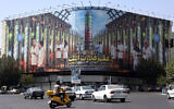 Iranians drive next to a billboard displaying pictures of nuclear scientists, centrifuges and a sentence reading in Farsi: 'Science is the power' at the Enqelab square in Tehran, on August 29, 2025 (AFP)