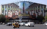 Illustrative: Iranians drive next to a billboard displaying pictures of nuclear scientists, centrifuges and a sentence reading 'Science is power' in Farsi, in Tehran, Iran, August 29, 2025. (AFP)