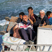 Displaced Palestinians fleeing south react as they ride in the back of a truck with belongings along the coastal road through Nuseirat in the central Gaza Strip on August 30, 2025. (Eyad BABA / AFP)