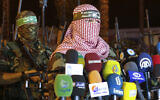 Abu Obeida (R), spokesman for the armed wing of Hamas, the Izz-ad-Din al-Qassam Brigades, delivers a statement in Gaza City late on July 8, 2015. (Mohammed ABED / AFP)