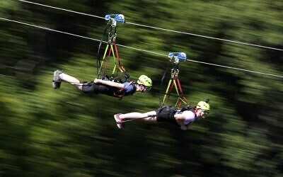 Illustrative -- People speed down a zipline in a fun park in Germany, July 19, 2022. (AP Photo/Matthias Schrader)