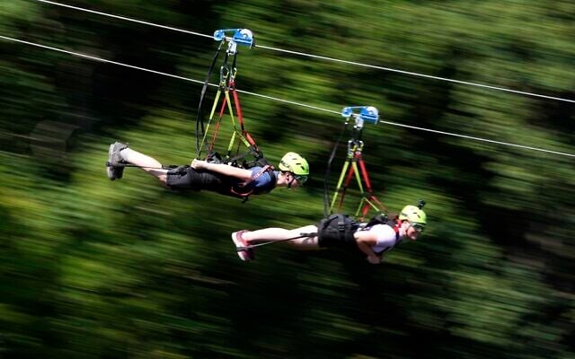 Illustrative -- People speed down a zipline in a fun park in Germany, July 19, 2022. (AP Photo/Matthias Schrader)