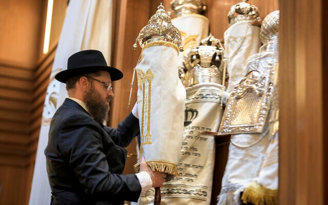 Illustrative: Rabbi Yehuda Teichtal prepares Torah scrolls at the synagogue of the Chabad community in Berlin, Germany, Friday, October 13, 2023. (AP Photo/Markus Schreiber)