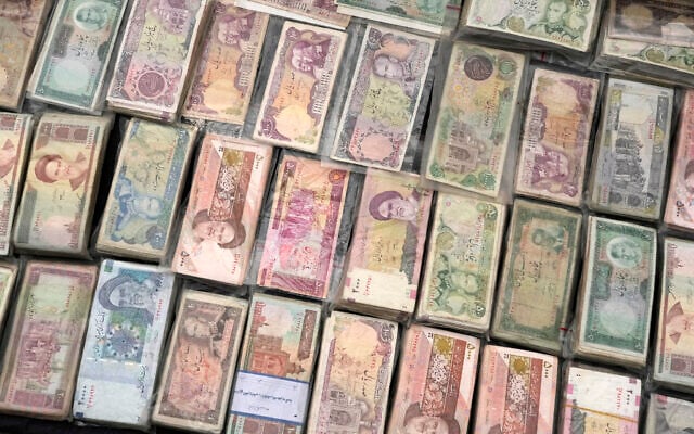 Current and pre-revolution Iranian banknotes are displayed by a vendor at Ferdowsi square, Tehran's go-to venue for foreign currency exchange, in downtown Tehran, Iran, February 5, 2025. (AP Photo/Vahid Salemi)