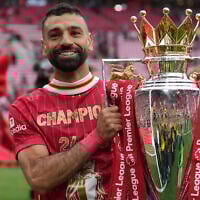 Liverpool's Mohamed Salah poses with the winner's trophy after the English Premier League soccer match between Liverpool and Crystal Palace at the Anfield stadium in Liverpool, England, Sunday, May 25, 2025. (AP Photo/Jon Super)
