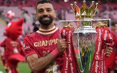 Liverpool's Mohamed Salah poses with the winner's trophy after the English Premier League soccer match between Liverpool and Crystal Palace at the Anfield stadium in Liverpool, England, Sunday, May 25, 2025. (AP Photo/Jon Super)