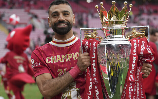 Liverpool's Mohamed Salah poses with the winner's trophy after the English Premier League soccer match between Liverpool and Crystal Palace at the Anfield stadium in Liverpool, England, Sunday, May 25, 2025. (AP Photo/Jon Super)
