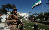 Illustrative: Syrian soldiers raise the Syrian national flag in front of the Syrian Defense Ministry building, which was heavily damaged by Israeli airstrikes, in Damascus, Syria, July 19, 2025. (AP Photo/Omar Sanadiki)