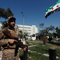 Illustrative: Syrian soldiers raise the Syrian national flag in front of the Syrian Defense Ministry building, which was heavily damaged by Israeli airstrikes, in Damascus, Syria, July 19, 2025. (AP Photo/Omar Sanadiki)