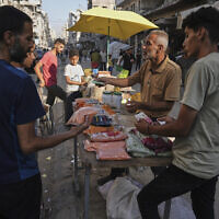 A Palestinian vendor displays goods for sale at a street market in Gaza City, July 23, 2025. (AP Photo/Jehad Alshrafi)